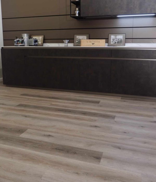 Pavimento vinilico SPC posato all'interno di un salotto moderno a Torino con mobili scuri.
